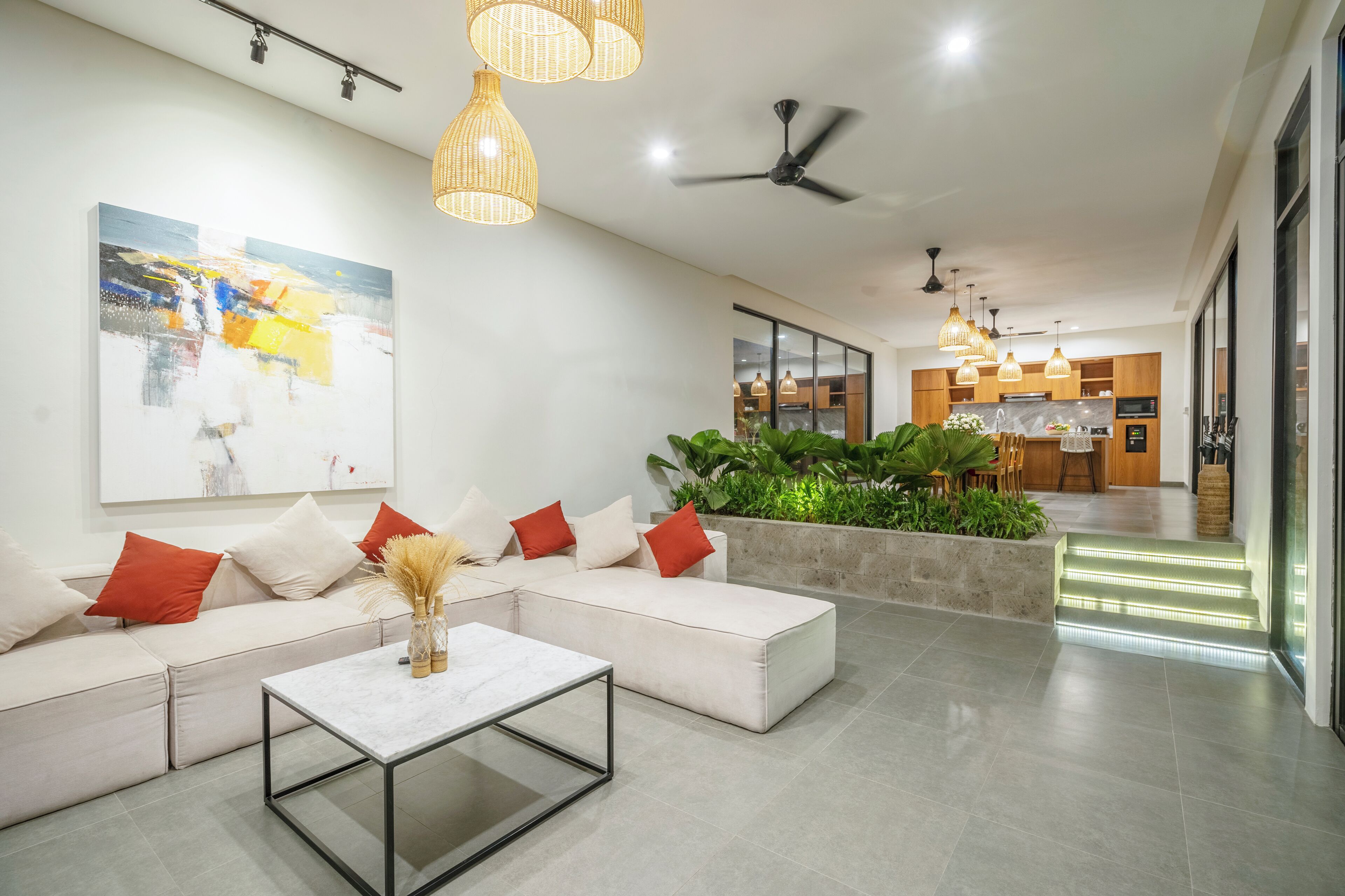 A modern living room with a sectional sofa, a coffee table, and a large abstract painting.