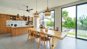 Une cuisine moderne avec des meubles en bois, un plan de travail en marbre et un grand îlot central doté de sièges.