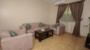 A living room with a sofa set, a coffee table, and a TV stand. - lina 2 (Dammam)