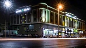 A hotel with a prominent sign, multiple floors, and a parking lot. - lina 2 (Dammam)