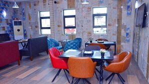 A dining area with a table, chairs, and a red couch.