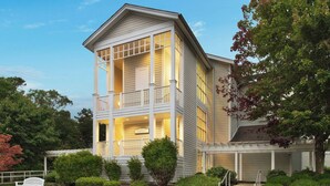 A two-story house with a balcony, a garage, and a well-maintained front yard with a bench and bushes. - Unwind in Style: Marriott Fairway Villas (Galloway)