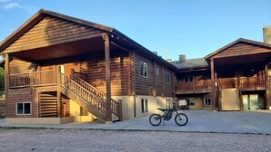 Une cabane en bois dotée d’un porche abrité et d’un escalier menant à un balcon.