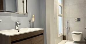 A modern bathroom with a white sink, wooden vanity, and a toilet. - Hittin A-11 Latest Development AZ13 (Riyadh)
