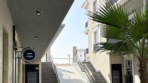 Ein modernes Gebäude mit Schachbrettboden, einer Treppe und einer Palme.