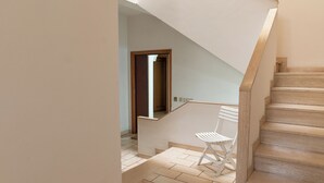 Una escalera de madera con peldaños y una silla blanca en la parte superior.
