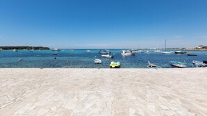 A marina with boats docked and a stone-paved area in the foreground. - 3873 Residence Kalura - Bilo 5 by Barbarhouse (Porto Cesareo)