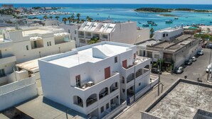 A coastal town with white buildings, a marina, and boats. - 3873 Residence Kalura - Bilo 5 by Barbarhouse (Porto Cesareo)