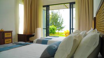 A hotel room with two beds, a desk, and a chair.