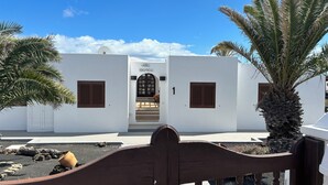 A white building with a sign reading "Villa Blanca," a wooden gate, and palm trees. - Fkk-apartment in Villa Blanca, 4 mit Schwimmbad und Zwei Schlafzimmer (Charco del Palo)