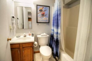 A bathroom with a toilet, sink, mirror, and shower curtain. - Mt Green Quick Walk to Lift Pool Sauna hot tub (Killington)