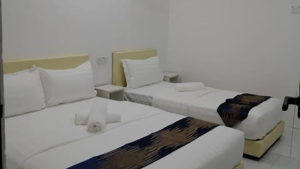 A hotel room with two beds, white bedding, a ceiling fan, and an air conditioning unit. - SKYN SMART HOME (Ipoh)