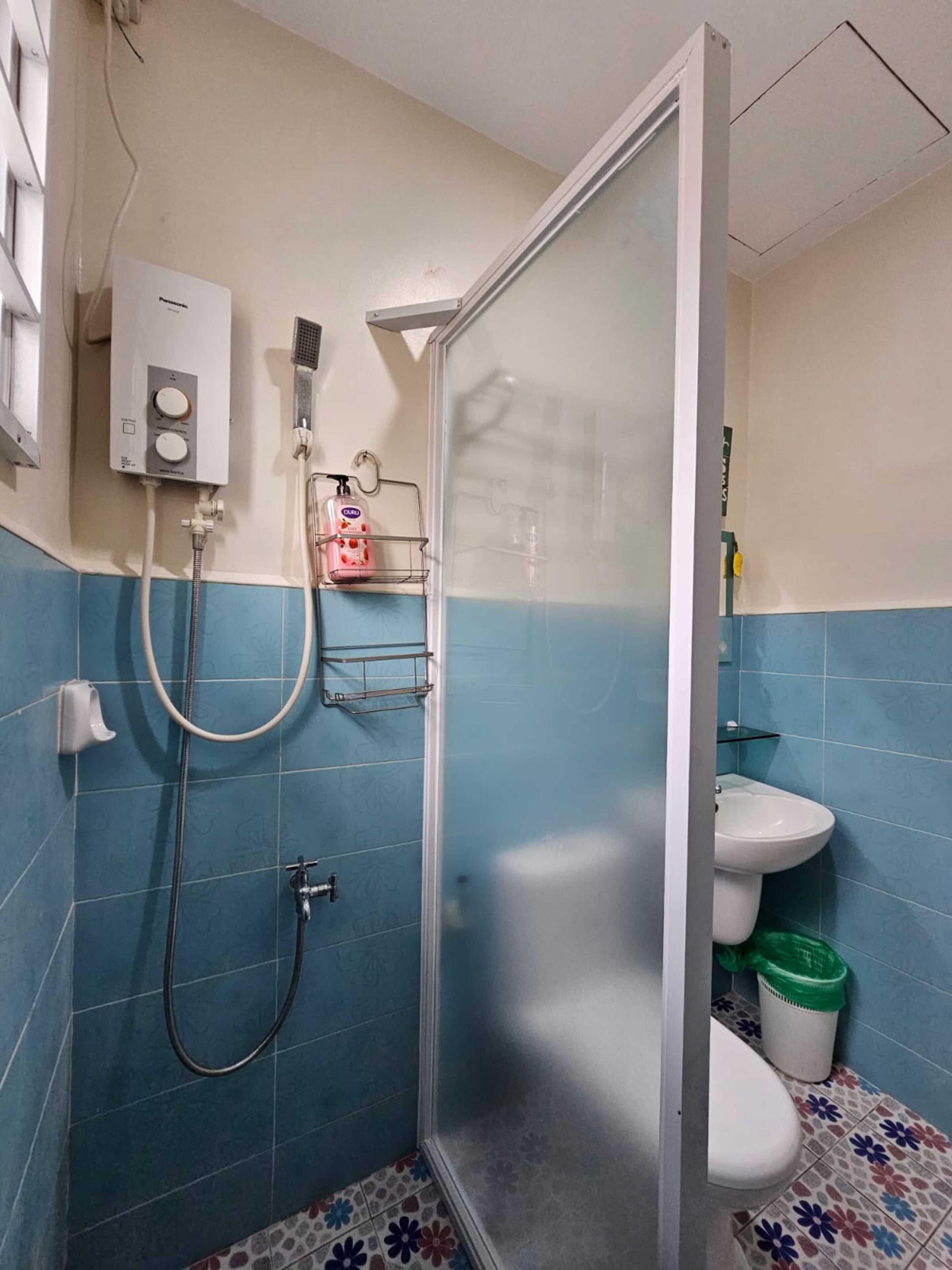 Ein Badezimmer mit Duschkabine, Toilette und Waschbecken.