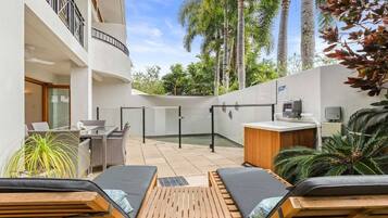Relax by the pool surrounded by lush greenery and comfortable lounge chairs.