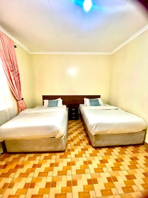 A room with two beds, a patterned floor, and a ceiling light. - Sungura Farm House (Nairobi)