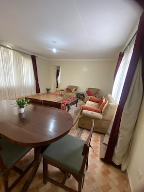 A living room with a dining table, chairs, sofas, and a coffee table. - Sungura Farm House (Nairobi)
