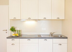 Fridge, stovetop, dishwasher, coffee/tea maker