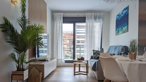 A modern living room with a dining area, large windows, and a view of the city. - CALA ALTA design apartment (Benidorm)