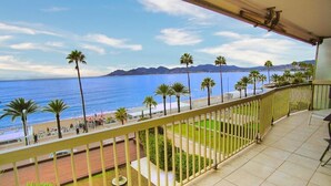 Ein Balkon mit Blick auf das Meer und Palmen.