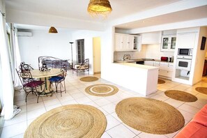 Enjoy meals in the central dining area with a round table and comfortable chairs.