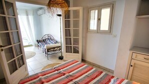 Ein Schlafzimmer mit Bett, Kleiderschrank und Fenster.