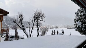 A snowy landscape with bare trees and a distant village. - Gemütliches Appartement für Erholung und Sport (Klosters-Serneus)
