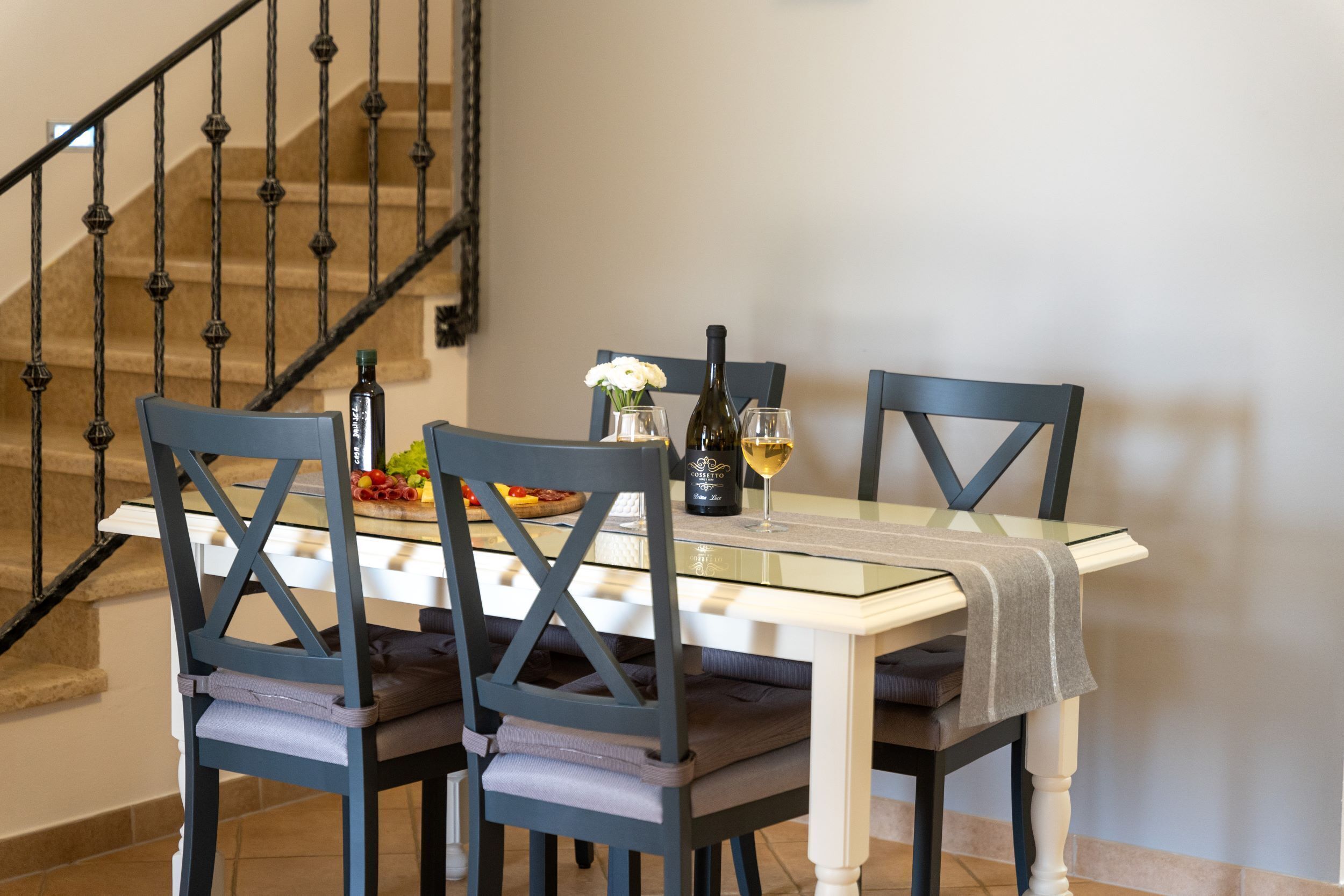 A dining area with a table set for two, featuring a wine bottle and glasses.