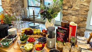 Una encimera de cocina bien equipada con diversos alimentos, utensilios y una planta en maceta.