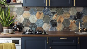 Een keuken met donkere kastjes, een backsplash van hexagontegels en een gasfornuis.