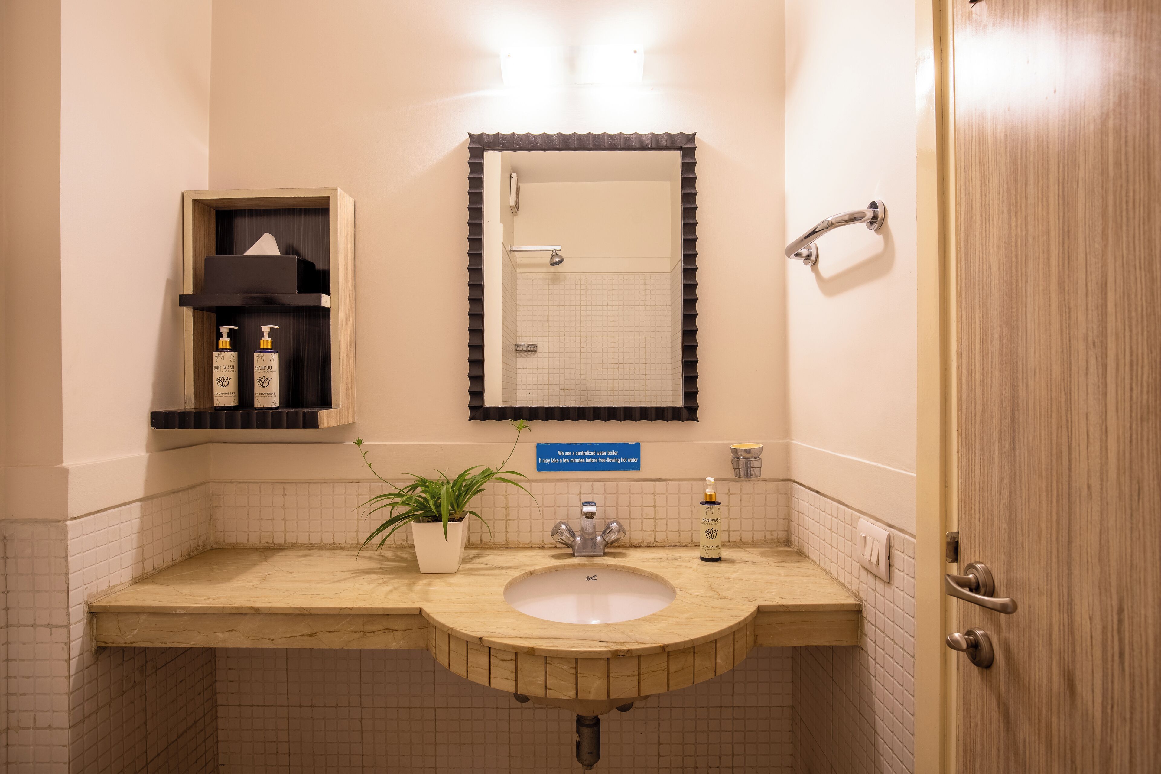 A bathroom with a sink, mirror, and a shelf with toiletries.