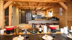 Un intérieur en bois avec un coin repas aménagé pour un repas, et une cuisine visible au fond.