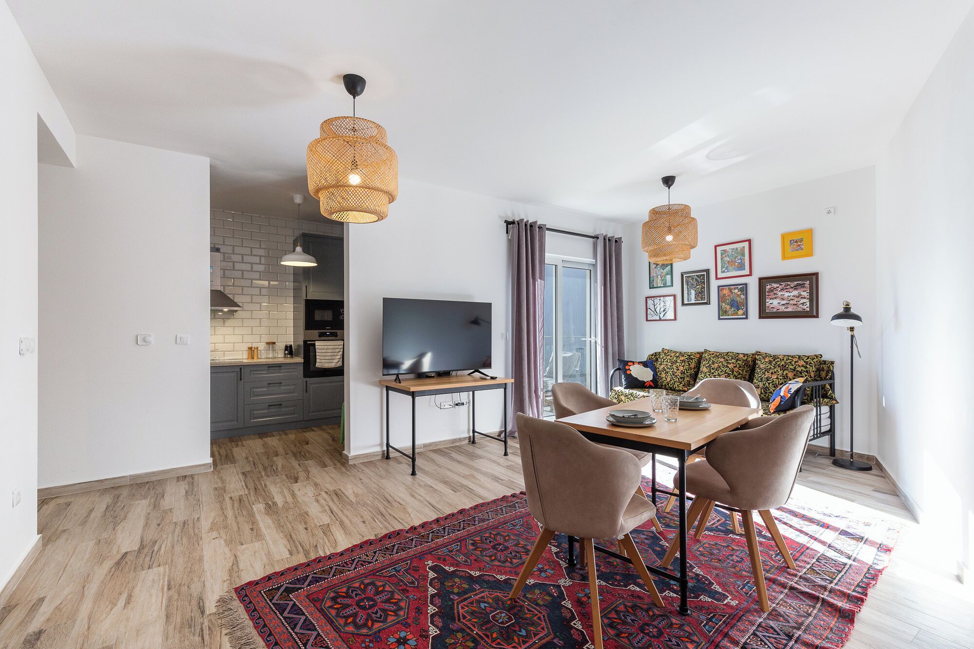 Ein modernes Wohnzimmer mit Essbereich, Fernseher und Sofa.