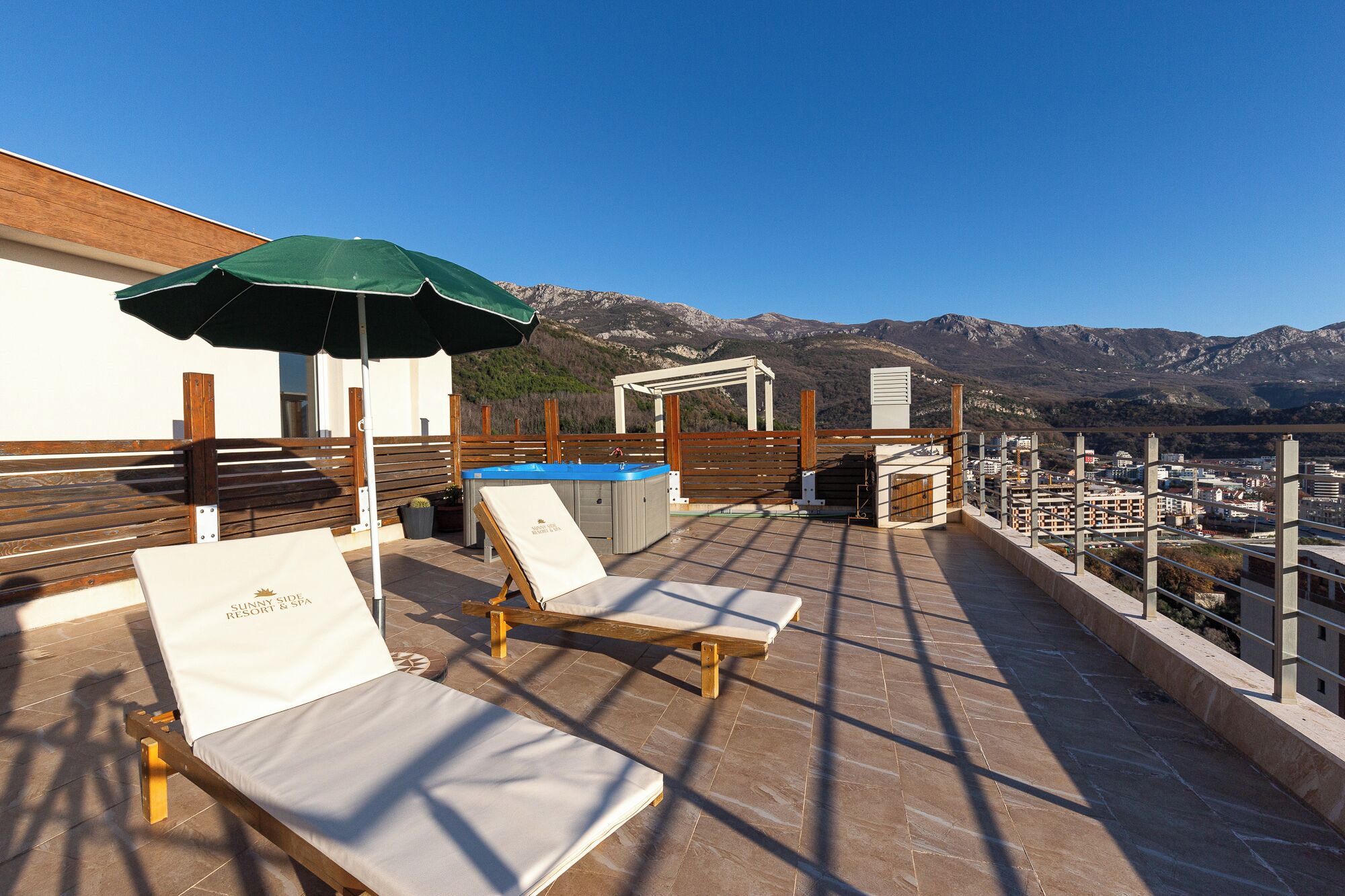 Terraza en la azotea con sillones de descanso, piscina y vistas a la montaña.