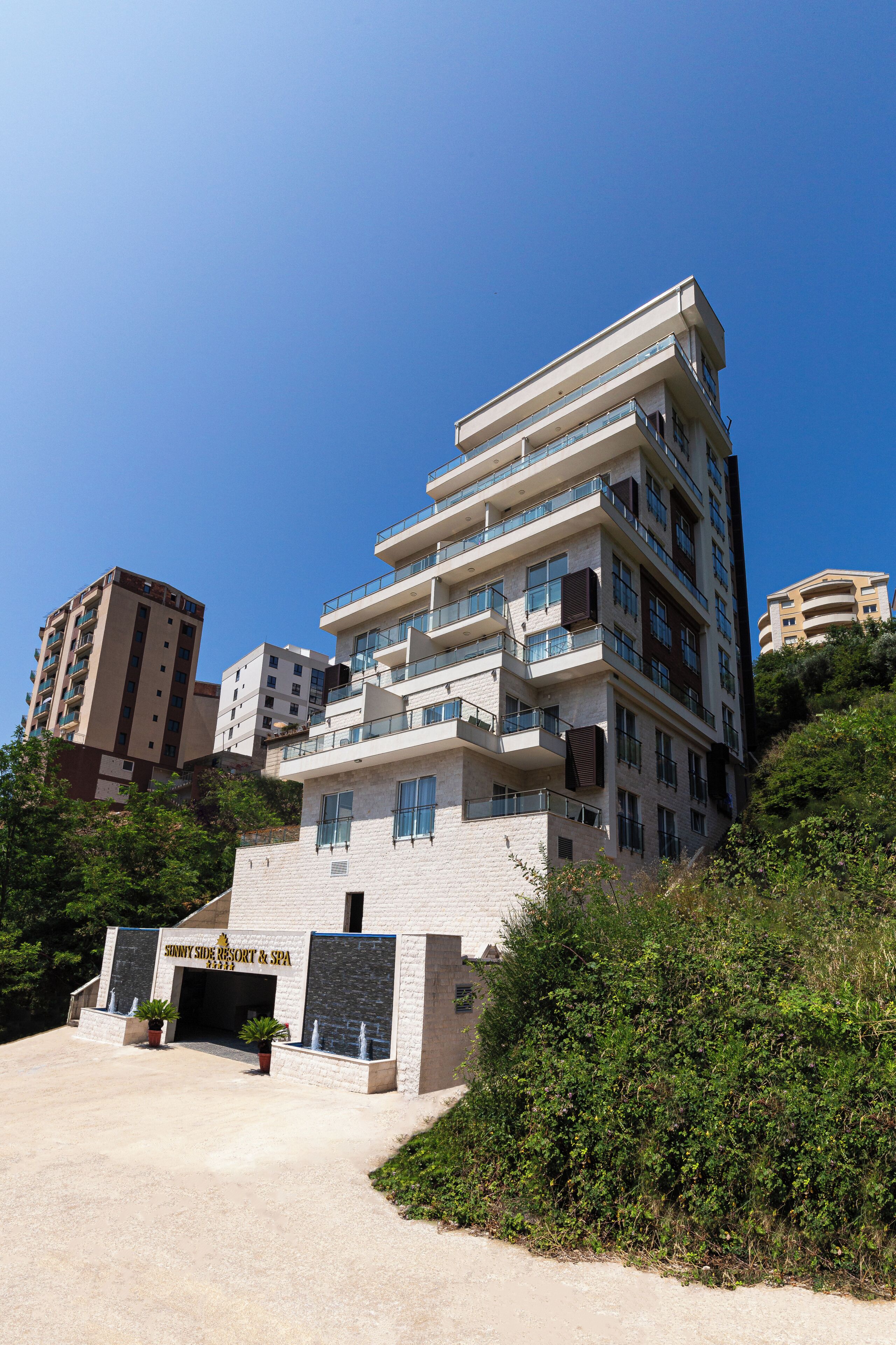 Un hotel de varios pisos con diseño moderno, que cuenta con balcones, un spa y el nombre del resort visible en la fachada.