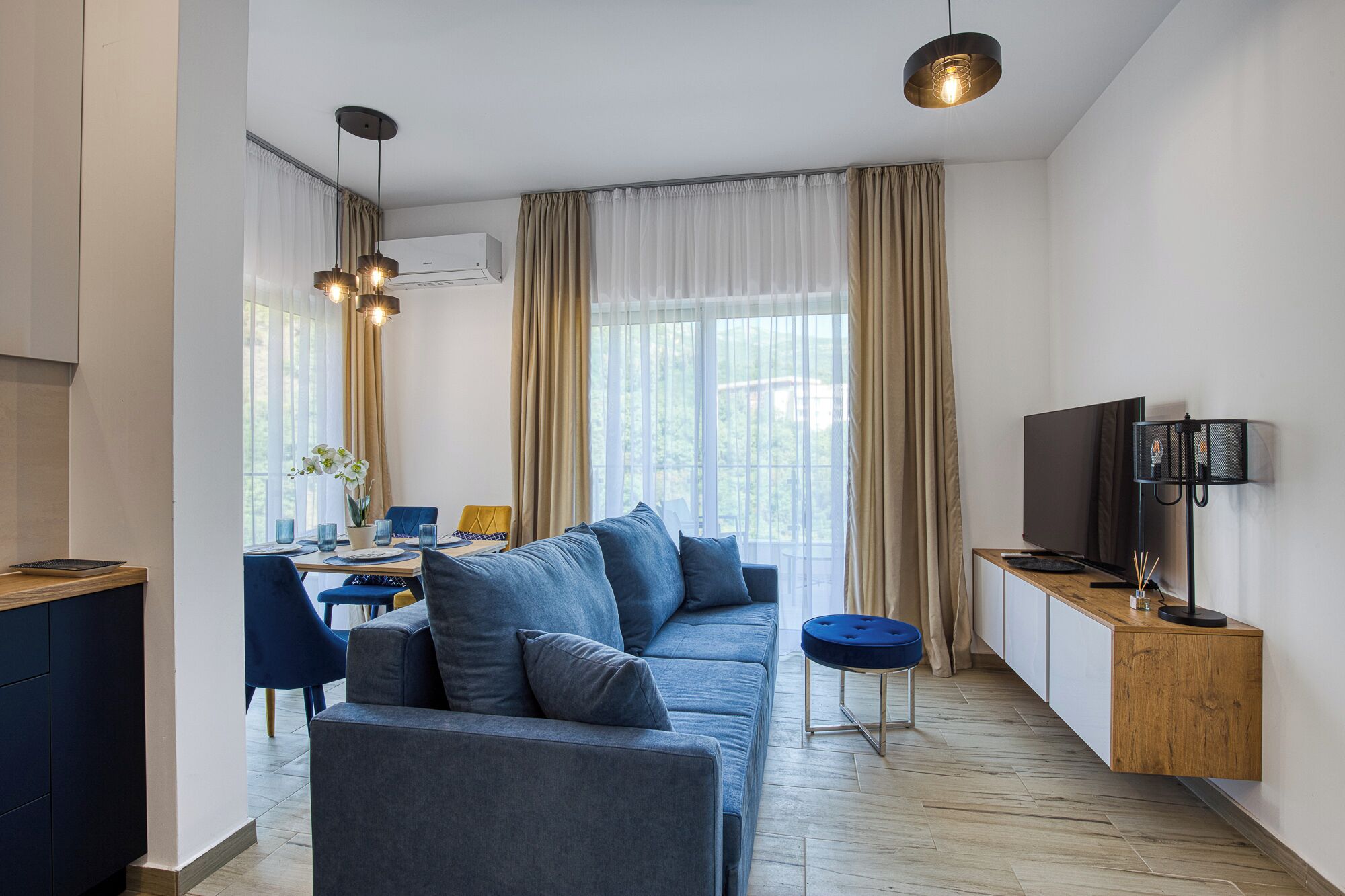 Una sala de estar moderna con un sofá, una mesa de comedor y un televisor.