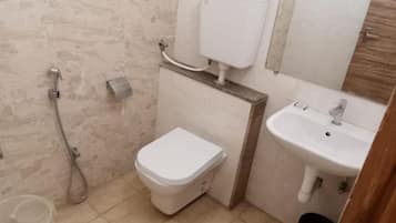 Une petite salle de bain avec des toilettes, un lavabo et une douche.