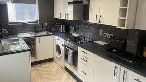 A modern kitchen with a built-in washing machine, a dishwasher, and a toaster. - Sheffield Spacious 4 Bedroom House-all En-suites (Sheffield)