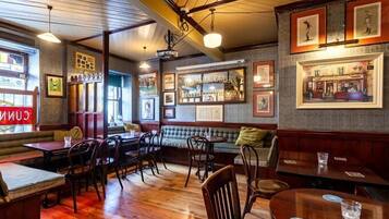 A cozy restaurant with wooden floors, cushioned seating, and framed pictures on the walls.