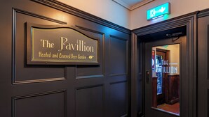 Una puerta de madera oscura con un letrero que dice "The Pavilion Heated and Covered Beer Garden".