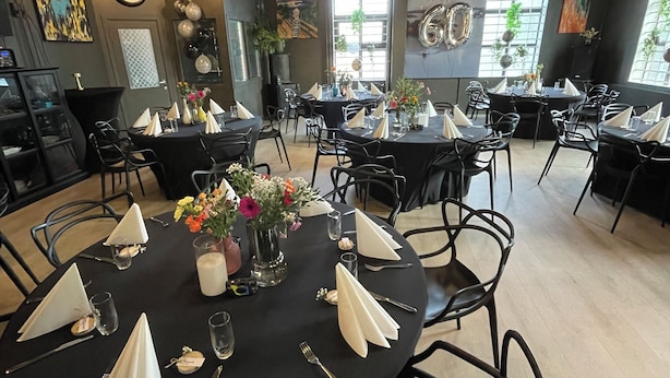 A restaurant with round tables set for dining, black chairs, and a modern industrial ceiling. - Fengselshotellet (Arendal)