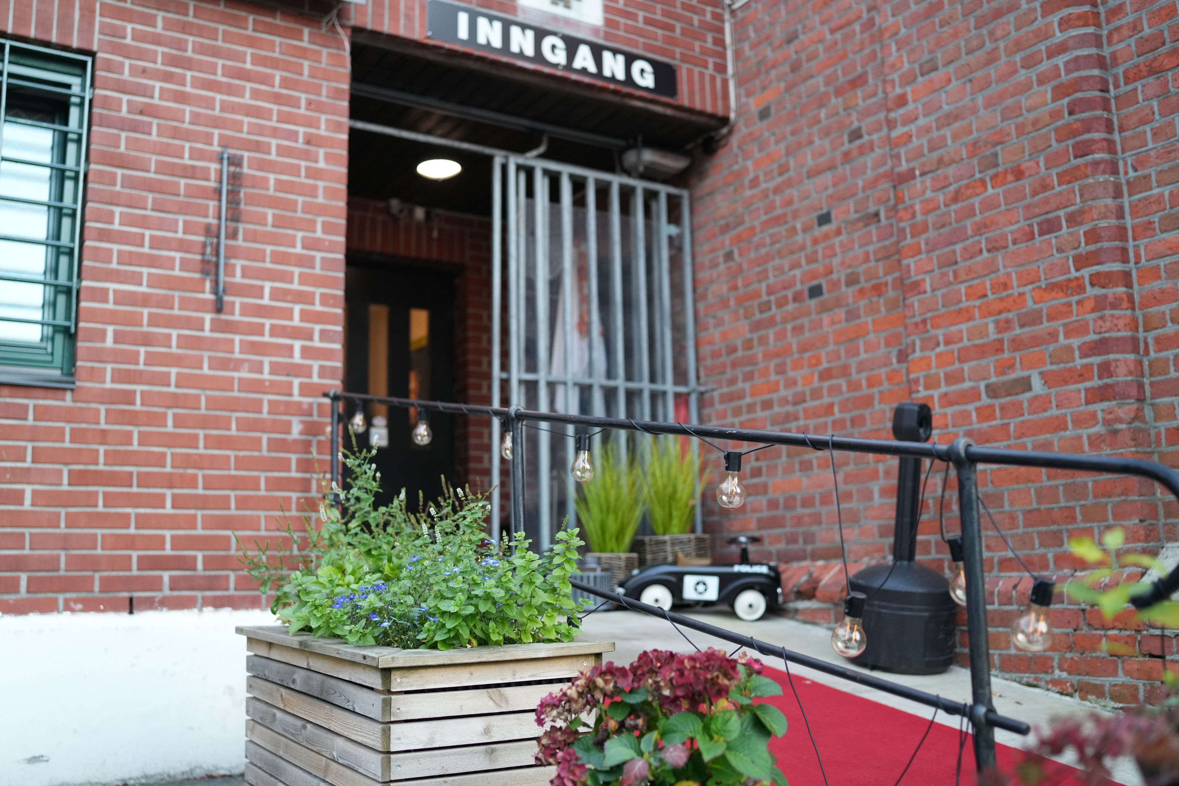 A brick building with a sign that reads 'INNGANG'.