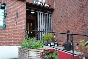 A brick building with a sign that reads 'INNGANG'. - Fengselshotellet (Arendal)