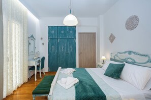 Une chambre à coucher comprenant un lit, un bureau, une chaise, une armoire et un miroir.