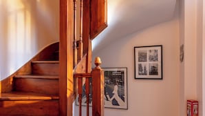 Eine hölzerne Wendeltreppe, die zu einer oberen Etage führt.