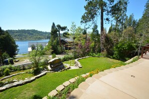 A well-maintained garden with a stone pathway, a small pond, and a view of a lake. - Fox Lake View with Boat Slip (Bass Lake)