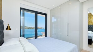 A bedroom with a bed, a large wardrobe, and a view of the sea. - Hedera Estate, Hedera A25 (Dubrovnik)