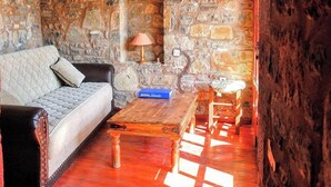 A rustic room with a stone wall, wooden furniture, and a stone fireplace. - Elounda Monastiri Cretan sea View House With Pool (Agios Nikolaos)