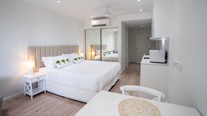 Une chambre d’hôtel moderne avec un grand lit, des tables de chevet, un bureau et une chaise.