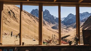 Zona de menjador amb una finestra gran que ofereix vistes a un paisatge de muntanya.