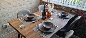 A wooden dining table set with black bowls, wine glasses, and cutlery. - The Hideaway ll /enclosed Garden/quiet/central (Southport)